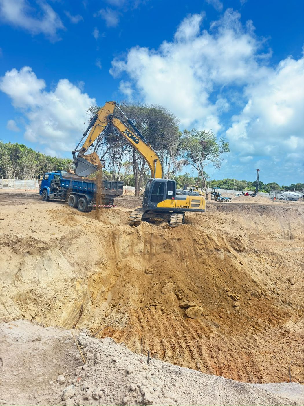 Escavadeira da APEX carregando caminhão em obra